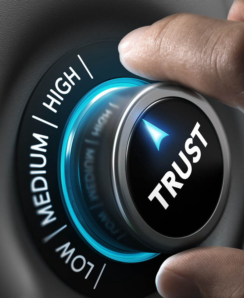 Image of a hand turning a dial labeled Trust towards High